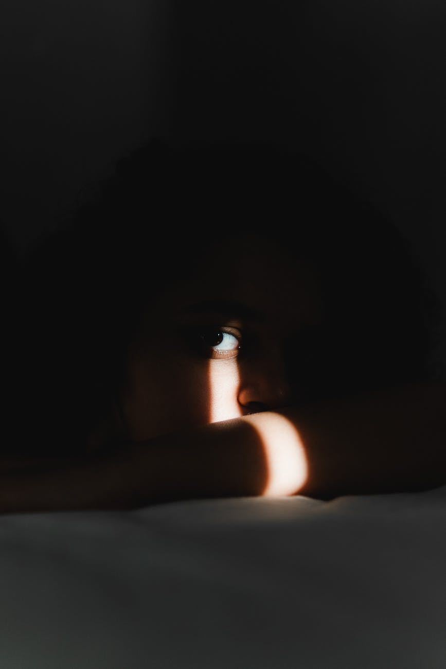 face hidden in darkness illuminated by small ray of light