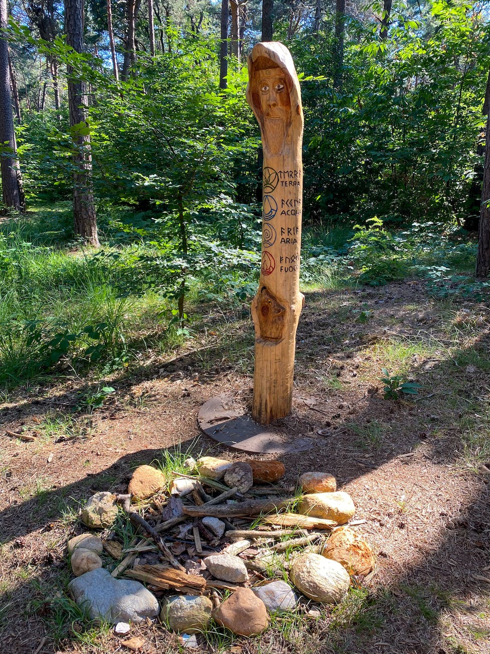 wooden pole with carvings near stones